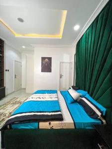 IkuataにあるLuxury Charming 5Bed Duplex With Starlink wifi - Lekkiのベッドルーム1室(緑のカーテン付きの大型ベッド1台付)