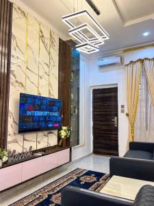 a living room with a television on a wall at Luxury Charming 5Bed Duplex With Starlink wifi - Lekki in Ikota