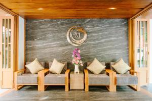 d'un salon avec deux canapés contre un mur dans l'établissement Moon Dragon Hotel, à Chiang Mai