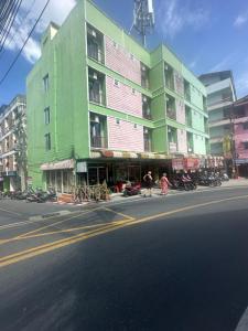 a green building on the side of a city street at T&R Wagner Appartaments in Patong Beach