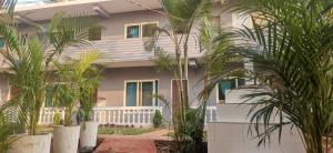 a building with palm trees in front of it at COCKS TOWN in Arambol