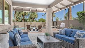 a patio with blue couches and a table and chairs at Luxe Central Scottsdale 4 bdrm w Backyard Oasis in Scottsdale