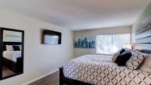 Schlafzimmer mit einem Bett und einem Spiegel in der Unterkunft Comfy 1-Bdrm Condo in Heart of Old Town Scottsdale in Scottsdale