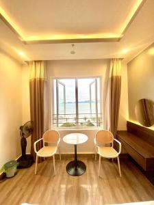 een kamer met een tafel en stoelen en een raam bij Dolphin Hotel in Cat Ba