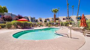 a swimming pool with tables and chairs in a resort at Contemporary Condo in Hub of Old Town Scottsdale in Scottsdale