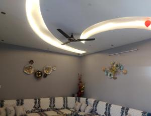 een woonkamer met een plafondventilator en een bank bij Aradhyas Stay in Jaipur