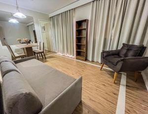 sala de estar con sofá, sillas y mesa en Paulista Flat, en São Paulo