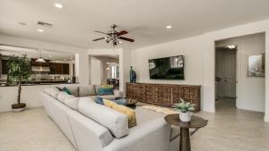 a living room with a couch and a ceiling fan at Amazing Litchfield Estate With Backyard Oasis in Litchfield Park