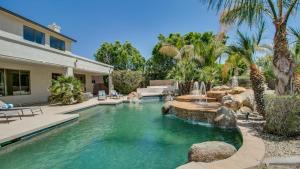 a swimming pool with a fountain in a yard at Amazing Litchfield Estate With Backyard Oasis in Litchfield Park