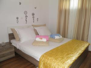 a bedroom with a bed with white sheets and a gold blanket at Apartment Leptir in Podstrana