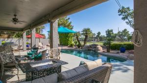een patio met een zwembad met stoelen en een tafel bij Spectacular Golf Course Home with Pool and Views in Gilbert