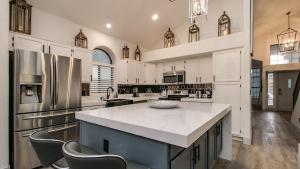 a large kitchen with white cabinets and a large island at Newly Renovated 4 Bedroom Retreat wPool in Phoenix