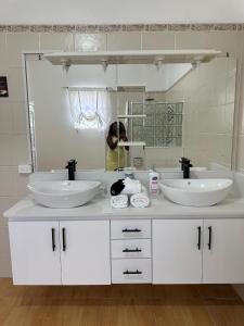 Eagles Nest Villa House AC TV WIFI Fan Luxury Modern في Albion: حمام به مغسلتين ومرآة كبيرة