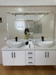a bathroom with two sinks and a large mirror at Eagles Nest Villa House AC TV WIFI Fan Luxury Modern in Albion +131 photos