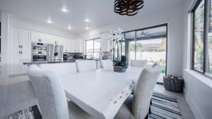 a white dining room with a white table and chairs at Just Listed Modern Showpiece wPool Hot Tub in Phoenix