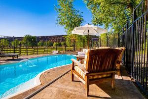 a chair and an umbrella next to a swimming pool at Zion on the 9 in Virgin