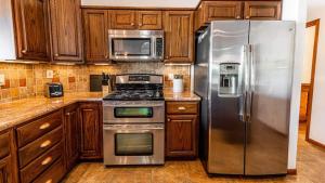 a kitchen with stainless steel appliances and wooden cabinets at Entertainers Dream in Scottsdale wPool and Games in Phoenix