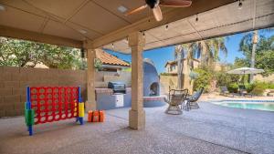 eine Terrasse mit einem Pool, einem Tisch und Stühlen in der Unterkunft Entertainers Dream in Scottsdale wPool and Games in Phoenix