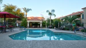 a swimming pool in a yard with tables and chairs at Gorgeous Upgraded Scottsdale Condo in Scottsdale