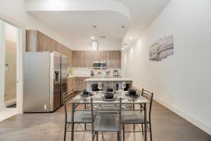 a kitchen with a table and chairs and a refrigerator at Cozy loft style 2BR I Gym I Parking I Workspace in Dallas