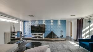 sala de estar con TV y pared azul en Vintage Charm w Modern Comforts Pool and Hot Tub, en Phoenix