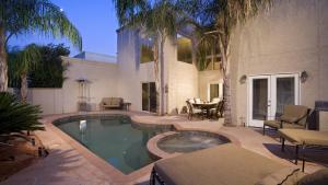 a swimming pool in front of a house at The Palm in Scottsdale