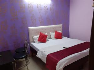 a bedroom with a bed with red pillows on it at Hotel City Lodge , Chandigarh in Manī Mājra