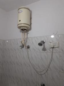 a shower with a white tank on a wall at Hotel City Lodge , Chandigarh in Manī Mājra