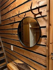 um espelho na parede de uma cabana de madeira em Rauhallinen kelohuoneisto lähellä palveluita, Peacefull Log apartment at Ylläs em Ylläsjärvi