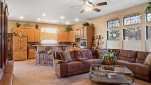 un soggiorno con divano marrone e una cucina di New listing Charming 4 bedroom with Pool a Peoria