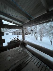 uma vista para um alpendre com neve no chão em Rauhallinen kelohuoneisto lähellä palveluita, Peacefull Log apartment at Ylläs em Ylläsjärvi