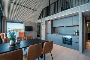 a kitchen and dining room with a table and chairs at CornerView Apartment Henningsvær in Henningsvær