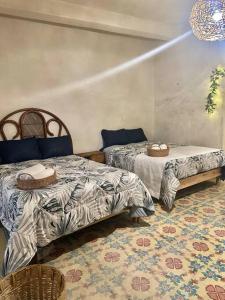 een slaapkamer met 2 bedden en een tapijt bij Casa Xpokin Camino Real 