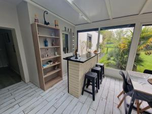 eine Küche mit einer Bar, einem Tisch und Stühlen in der Unterkunft Magnifique villa Boubou 300m2 avec piscine in Troarn