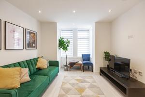 uma sala de estar com um sofá verde e uma televisão em Pembroke Heights em Chatham