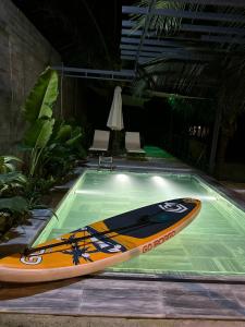 a surfboard is sitting in a swimming pool at MAYHOME Ninh Chu - Phòng đôi lớn in Bắc Sớn