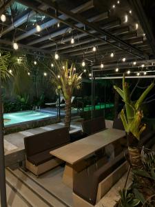 un patio con mesa, sillas y piscina en MAY HOME Ninh Chu en Bắc Sớn