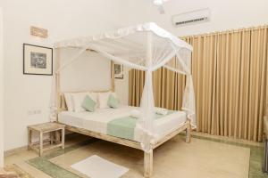 a bedroom with a bed with a canopy at Aurora in Unawatuna