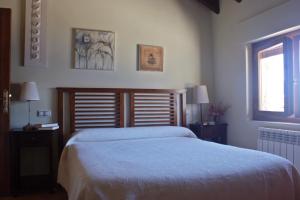 a bedroom with a large bed and two windows at Posada Real El Sendero del Agua in Trefacio