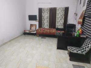 ein Wohnzimmer mit einem Sofa und einem Stuhl in der Unterkunft Baba Boys Hostel and Baba Trailer Truck Transport in Lucknow