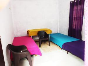 ラクナウにあるBaba Boys Hostel and Baba Trailer Truck Transportのベッド2台と椅子2脚が備わる客室です。