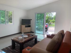 a living room with a couch and a table at Pajaree and Udo‘s Happy Homestay in Trang