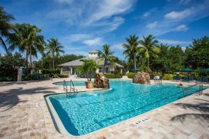 una piscina en un complejo con palmeras en Positano Vacation Rental, en Lely Resort
