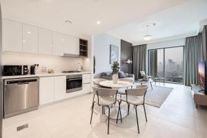 a kitchen and living room with a table and chairs at SmartStay at Downtown Views - Best Burj Khalifa View - Brand New Luxury Apartments in Dubai