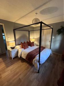 1 dormitorio con 1 cama con dosel negro en Woodside Lodge, Weybourne, Holt, en Weybourne