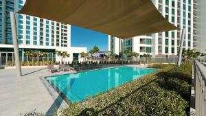 a swimming pool with a large umbrella in front of a building at SmartStay at Downtown Views - Best Burj Khalifa View - Brand New Luxury Apartments in Dubai