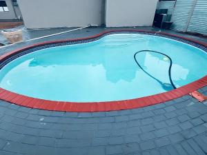 a large swimming pool with a hose in it at Mudix Royal Palace Guest Lodge in Musina