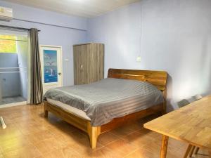 - une chambre avec un lit et une table en bois dans l'établissement Makorn Nonkleng, à Ban Yung