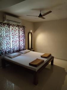 a bedroom with a bed with a curtain and a window at Konkan Villa Dream in Malvan