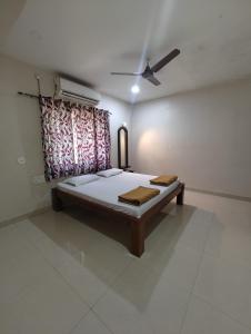 a bed in a room with a ceiling fan at Konkan Villa Dream in Malvan